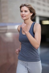 Woman running on city street --- Image by © Hybrid Images/cultura/Corbis